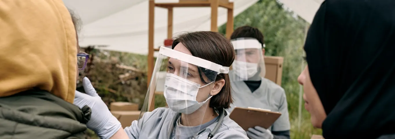 "Public Health worker helping person outdoors"
