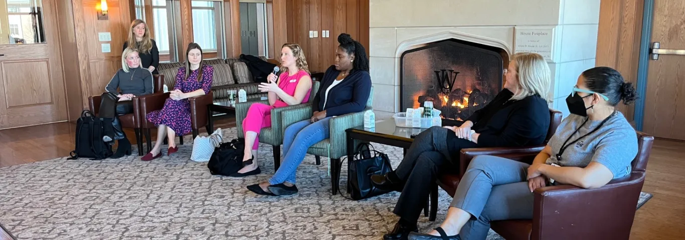 Photo from the career panel showing all six panelists sitting in front of a fireplace