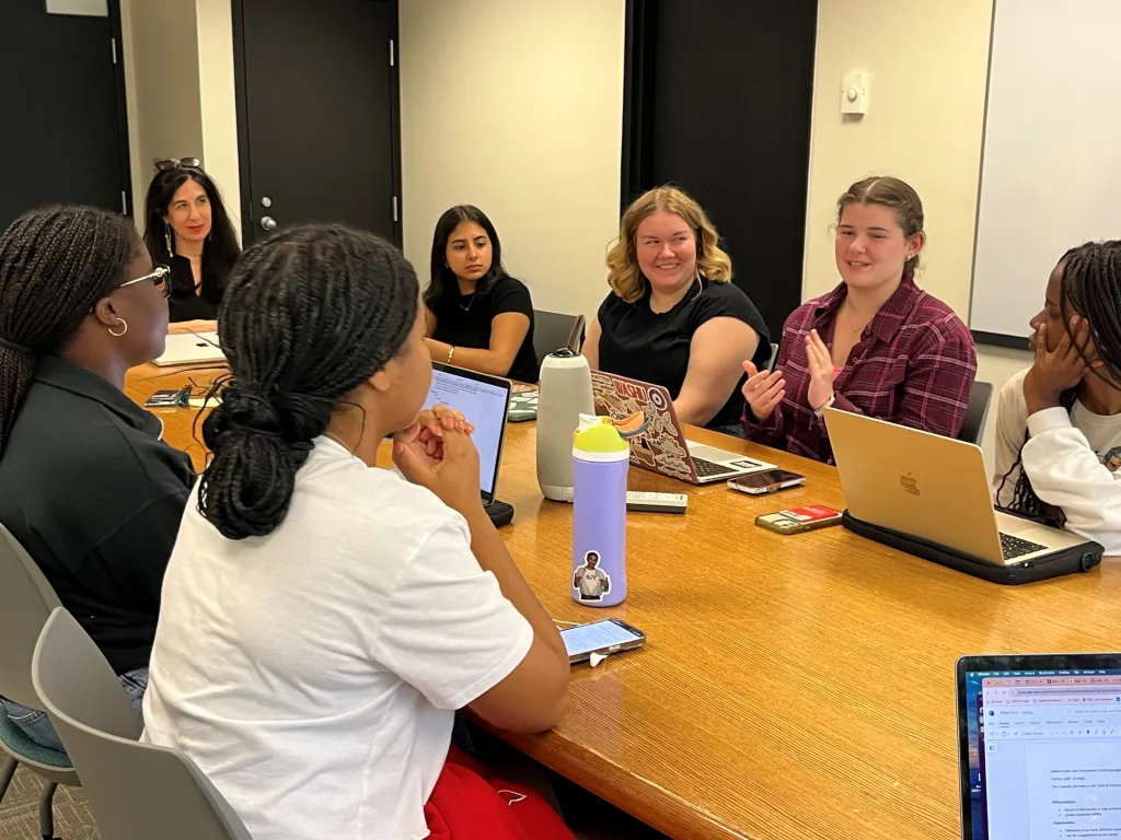 "students conversing in a seminar room"