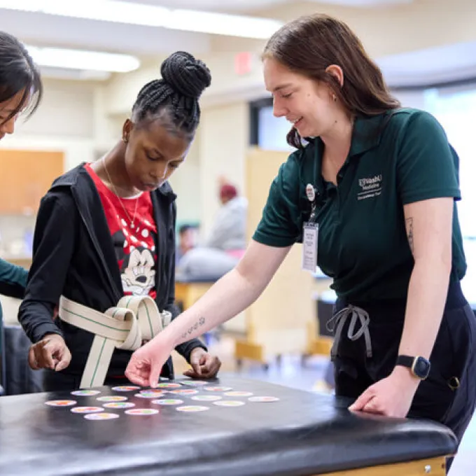 Lapada Pavanacharoensuk (left), a WashU Medicine physical therapy student volunteer, and Mackenzie Halton (right), a WashU Medicine occupational therapy student leader, work together with a patient on balance, motor skills and memory at the Pro Bono Health Clinic. Medical, occupational therapy and physical therapy students provide services to uninsured and underinsured community members every Friday afternoon.