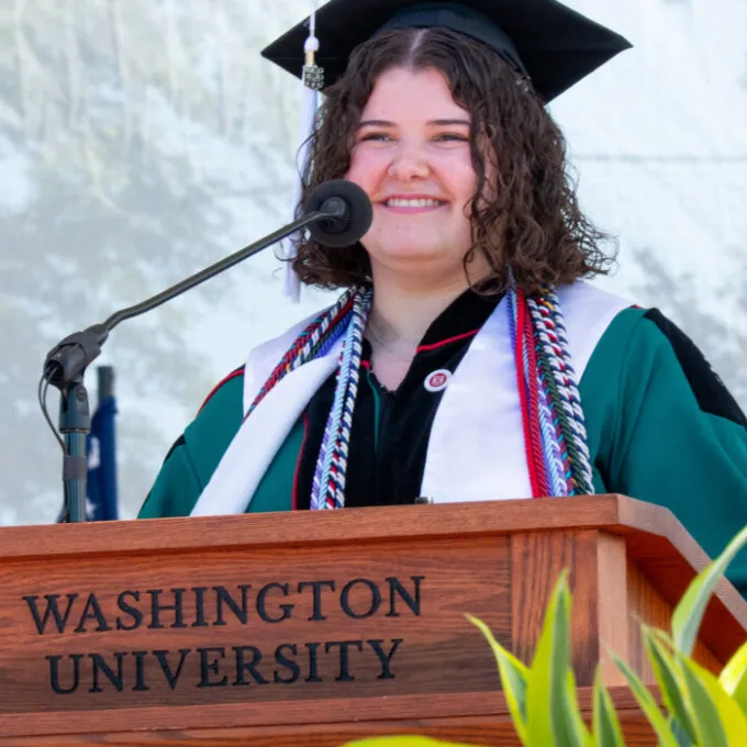 Mia Kouveliotes, AB ‘26, speaks at the 2026 College of Arts & Sciences Recognition Ceremony, May 14. As a student ambassador for the Public Health & Society program in Arts & Sciences, Kouveliotes helped shape curricular pathways and communicate its mission to prospective students. (Photo: Sean Garcia/WashU)
